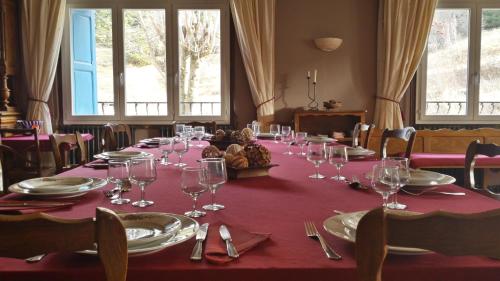 una mesa larga con copas de vino y servilletas. en Mouli Del Riu en Saint-Pierre-dels-Forcats