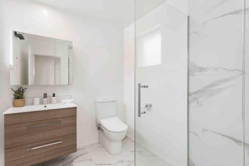 a bathroom with a toilet and a glass shower at Exceptional Value For Money Sunny Warm 5 Mins CBD in Christchurch