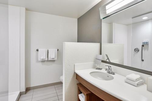 a bathroom with a sink and a mirror at Courtyard by Marriott St. Petersburg Clearwater/Madeira Beach in St Pete Beach