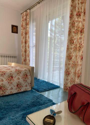 a bedroom with a bed and a large window at Rapsodia Pension in Suceava