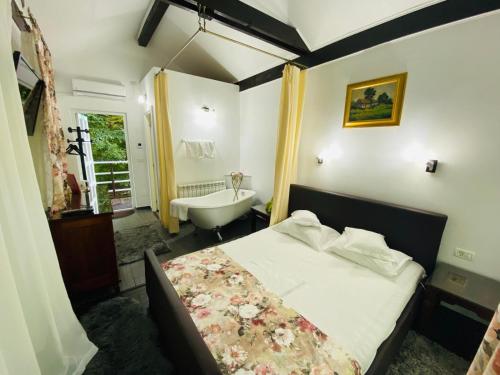 a bedroom with a bed and a tub and a sink at Rapsodia Pension in Suceava