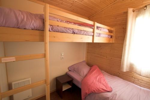 a bedroom with two bunk beds in a cabin at Les Cottages du Limonay in Saint-Méloir-des-Ondes