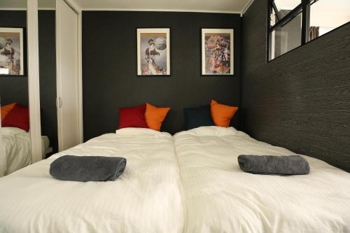 a bedroom with two beds with pillows on them at 東京スカイツリー眺望 一棟貸切 駅徒歩50秒 浅草8分 スカイツリー4分 銀座20分 in Tokyo