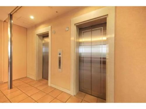 an empty hallway with a metal elevator in a building at R&B Hotel Shin Yokohama Ekimae - Vacation STAY 14692v in Yokohama