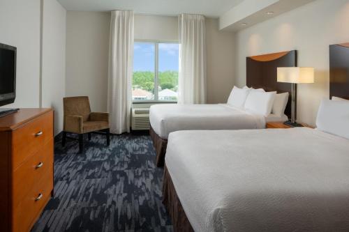 a hotel room with two beds and a television at Fairfield Inn & Suites Orange Beach in Orange Beach