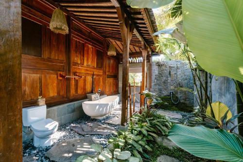 a bathroom with a toilet and a bath tub at Madani Antique Villas in Ubud
