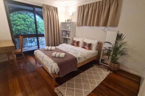 a bedroom with a bed with pillows and a window at Big Holliday house with pool in Brisbane