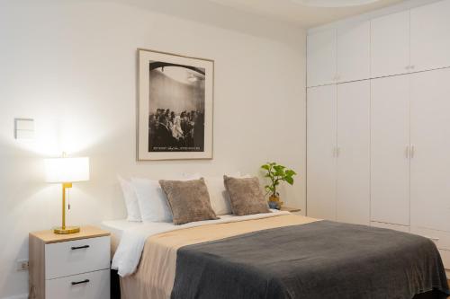 a white bedroom with a large bed and a lamp at 3Bedrooms City Nimman in Chiang Mai
