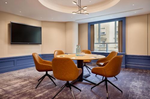 a conference room with a table and chairs and a tv at Sheraton Zagreb Hotel in Zagreb