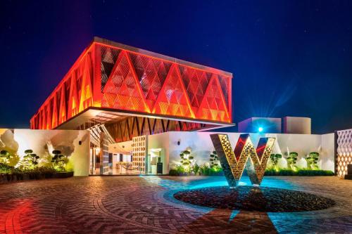 a building with a red building with a fountain in front at W Goa in Vagator