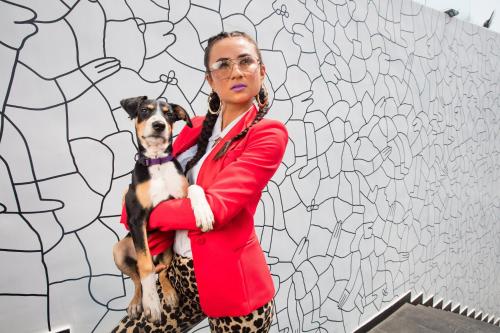 a woman holding a dog in front of a wall at W Goa in Vagator