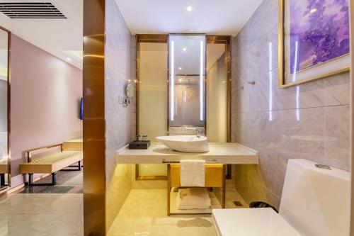 a bathroom with a sink and a mirror at Yunyuexi Hotel - Guangzhou Baiyun Cengang Branch in Guangzhou