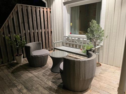 a patio with three chairs and a table and a bench at Villa lilla lavendel in Kungsängen