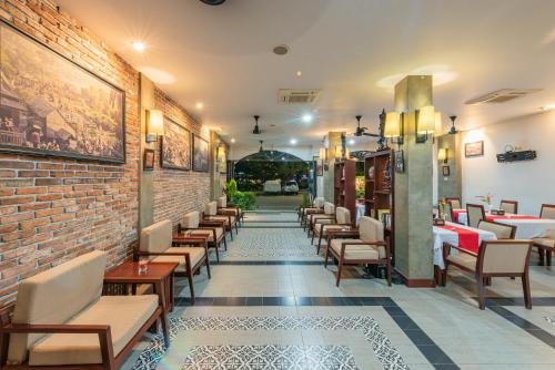 un ristorante con una fila di sedie e un muro di mattoni di Shadow Angkor Residence a Siem Reap