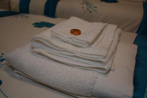 una pila de toallas sentadas encima de una cama en Wallace Apartment en Stirling