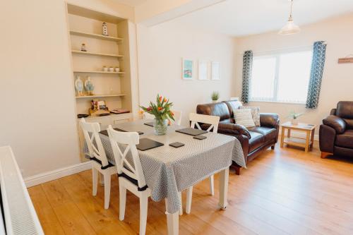 a kitchen and living room with a table and chairs at Harbour Reach - 2 storey apartment in Saundersfoot in Saundersfoot