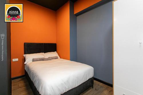 a bedroom with an orange and blue wall with a bed at ninna-Paris Squre in Haifa