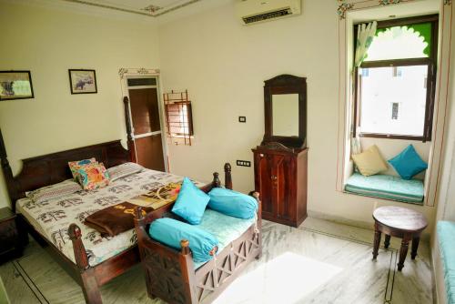 a bedroom with a bed with blue pillows at Whereabout Hostel Udaipur in Udaipur