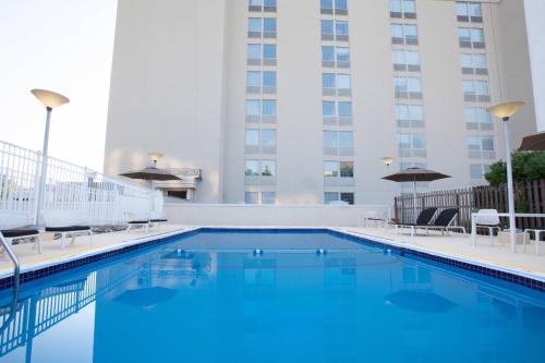 a swimming pool with chairs and a building at Sheraton Pittsburgh Airport Hotel in Coraopolis