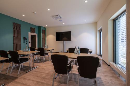 a conference room with tables and chairs and a flat screen tv at Residence Inn by Marriott Hamburg Altona in Hamburg