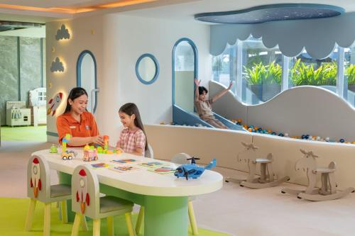 a woman and a child playing in a play room at Yogyakarta Marriott Hotel in Yogyakarta