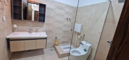 a bathroom with a toilet and a sink and a shower at Sapphire Residency in Niāziān