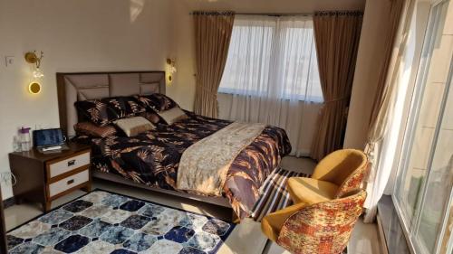 a bedroom with a bed and a chair and a window at Sapphire Residency in Niāziān