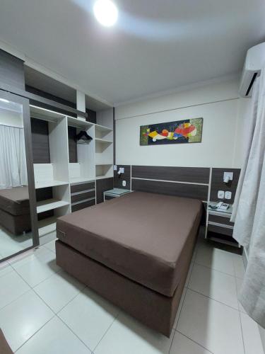 a small bedroom with a bed and shelves at Lacqua diRoma 1 - Apartamentos JN in Caldas Novas