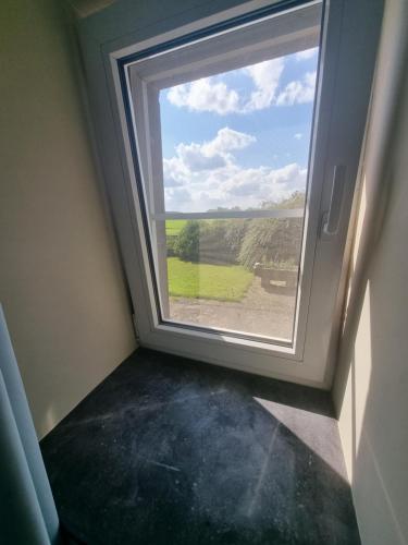 a window in a room with a view of a field at groot authentiek en charmante woning, 250 vierkante meter, panoramisch vergezicht, zonsondergang, dicht bij Dinant, Maredsous en Namen in Gay