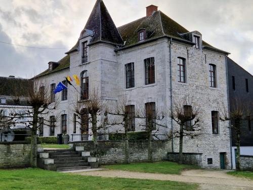 an old stone building with a flag on it at groot authentiek en charmante woning, 250 vierkante meter, panoramisch vergezicht, zonsondergang, dicht bij Dinant, Maredsous en Namen in Gay