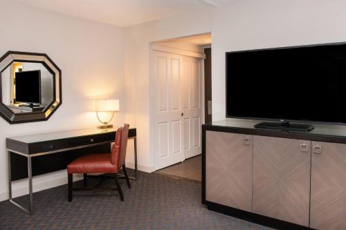 a hotel room with a desk and a flat screen tv at Sheraton Minneapolis West Hotel in Minnetonka