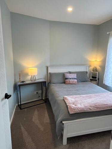 a bedroom with a bed with a pink blanket on it at Fabulous, New, Well Appointed Beach House in Kingston Beach