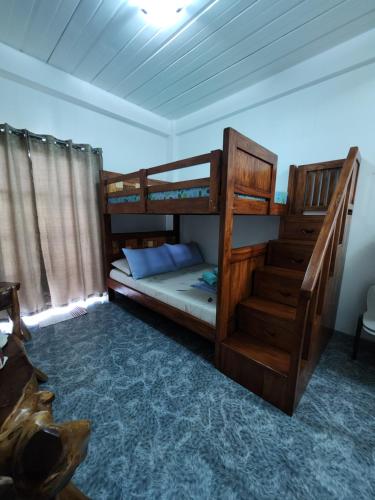 a bedroom with two bunk beds and a staircase at ASHBURN'S TRANSIENT Bauang LA UNION- SELF CHECK-IN, SELF SERVICE in Bauang
