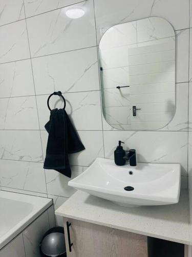 a white bathroom with a sink and a mirror at KT Comfort in Midrand