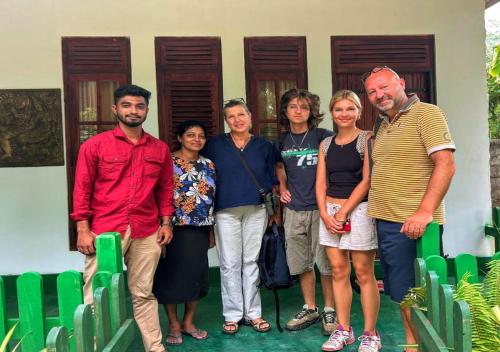 a group of people standing in front of a house at Jm Resort in Dambulla