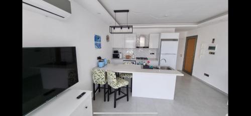 a white kitchen with a counter and stools at the best place in Karavas