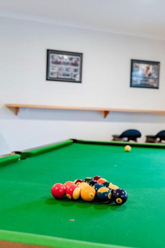 a pool table with balls on top of it at Currawong At Cowes in Cowes
