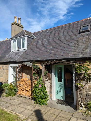 a house with a green door and a building at Myrtle Cottage Findhorn in Forres