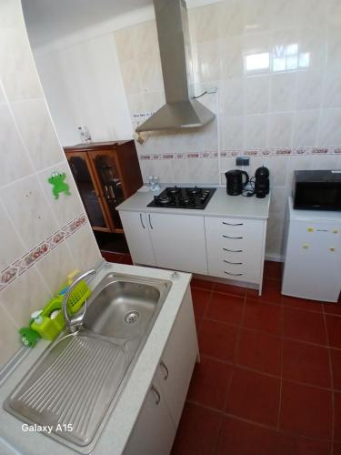 a small kitchen with a sink and a stove at Casa da Padaria in Caldas da Rainha