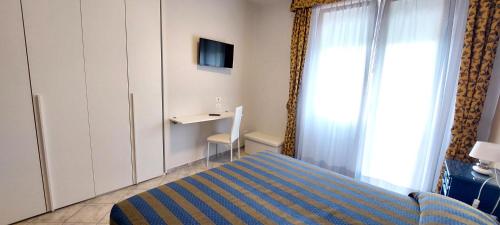 a bedroom with a bed and a desk and a window at Hotel Viña del Mar Pineta in Lido di Jesolo