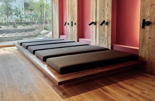 a row of beds in a room with pink walls at Bio Design Appartements DAS GRAUE SCHAF - Kärnten Card im Sommer inklusive in Bad Kleinkirchheim