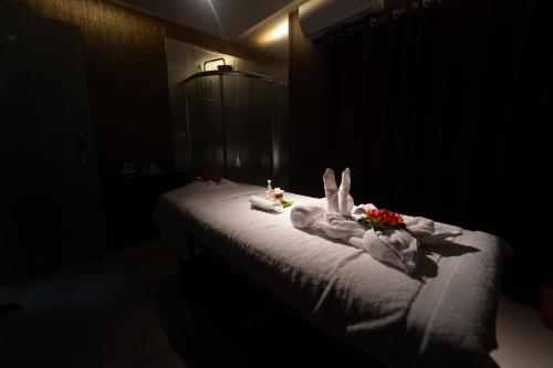 a bed in a dark room with towels and flowers on it at Paragon Hotel & Resort in Sreemangal