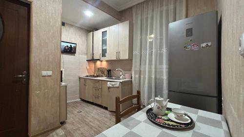 a small kitchen with a table and a refrigerator at Guest House Maria in Sighnaghi