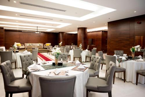 a banquet hall with tables and chairs in a room at Ruve Jeddah Hotel in Jeddah