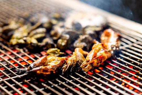 a bunch of food is cooking on a grill at Paragon Hotel & Resort in Sreemangal
