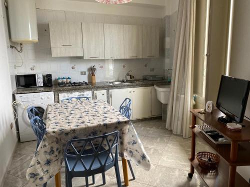 a kitchen with a table with blue chairs and a kitchen with a sink at Casa vacanze anto antonella in Bagheria