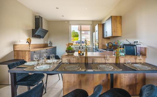 a kitchen with a table with wine glasses on it at La Maison du Douanier Apach in Apach