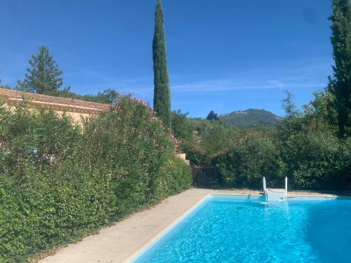 una piscina con una silla en un jardín en Les chambres des Baronnies, en Buis-les-Baronnies