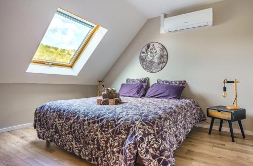 a bedroom with a bed with purple sheets and a window at La Maison du Douanier Apach in Apach