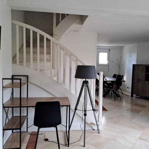 - un salon avec un escalier, une table et des chaises dans l'établissement Le Beltremieux, à La Rochelle